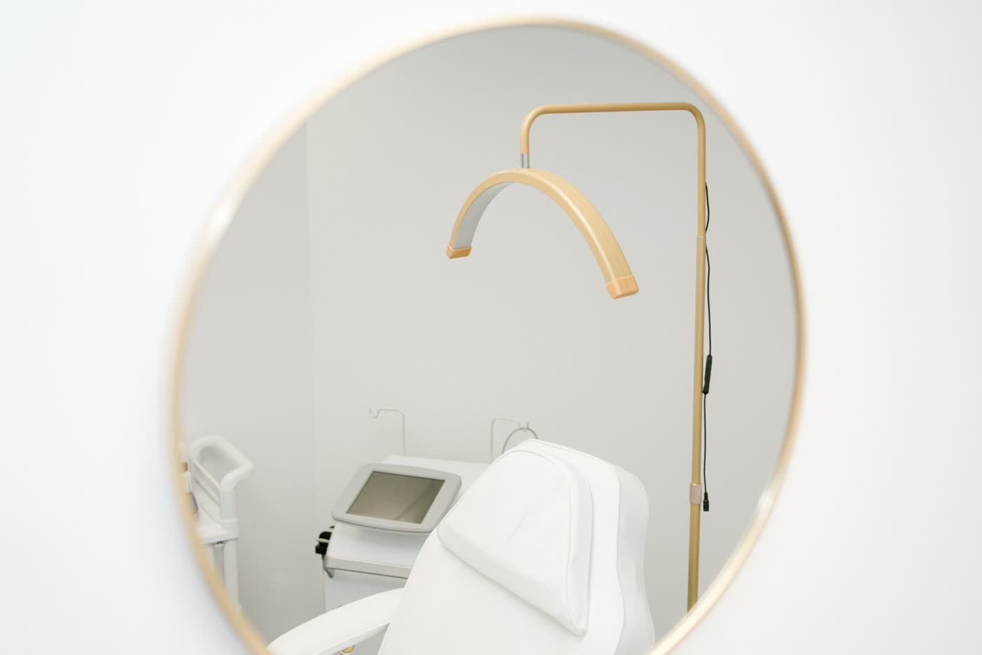 A candlelit treatment room at The Nightingale Wellness Clinic: navy walls, warm gold light and a cream treatment chair